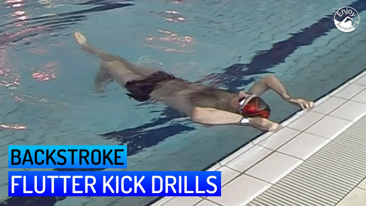 A novice swimmer practicing flutter kick drills for the backstroke.