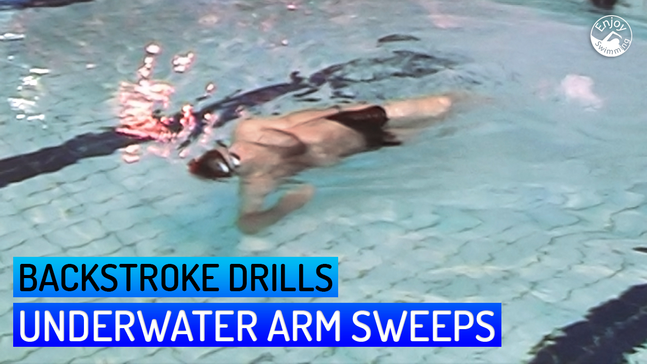 A novice swimmer who practices an underwater arm sweep drill for the backstroke.