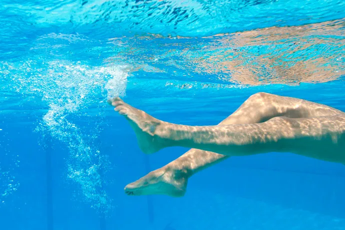 Close-up of the legs of a backstroke swimmer.