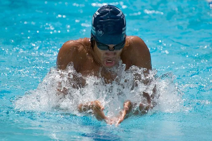 A breaststroke swimmer breathing in during the arm recovery.