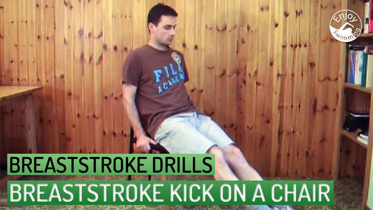 A swimming instructor demonstrates how to practice the breaststroke kick movements while sitting on a chair