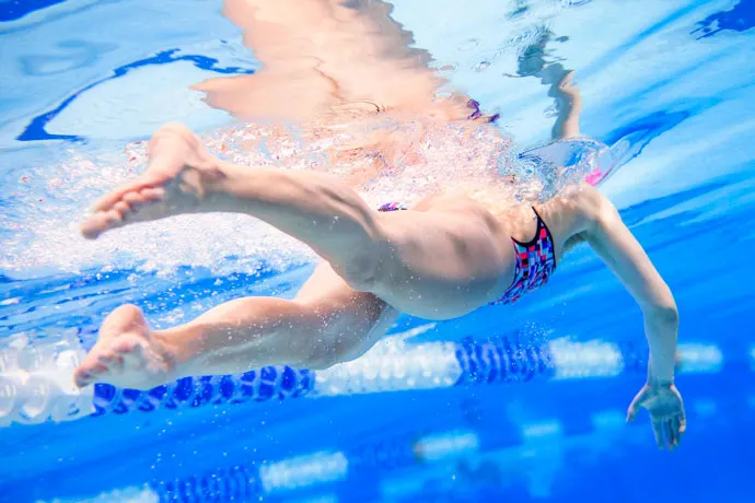 Underwater shot of a female front crawl swimmer in which the leg movements are the focus.
