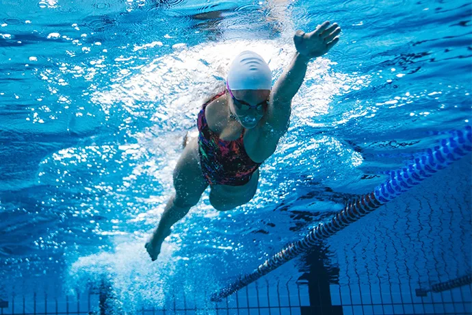 Underwater view of a female freestyle swimmer gliding nicely on her side.