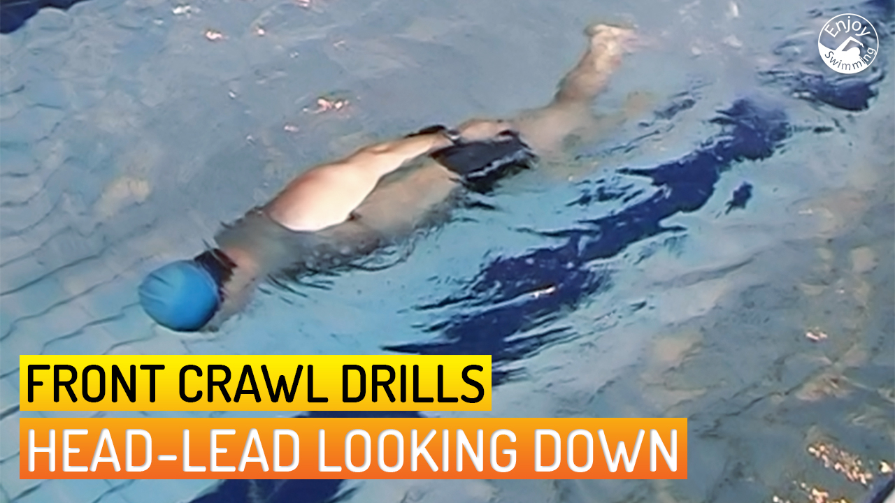 A novice swimmer who practices the head-lead looking down drill for the front crawl stroke.