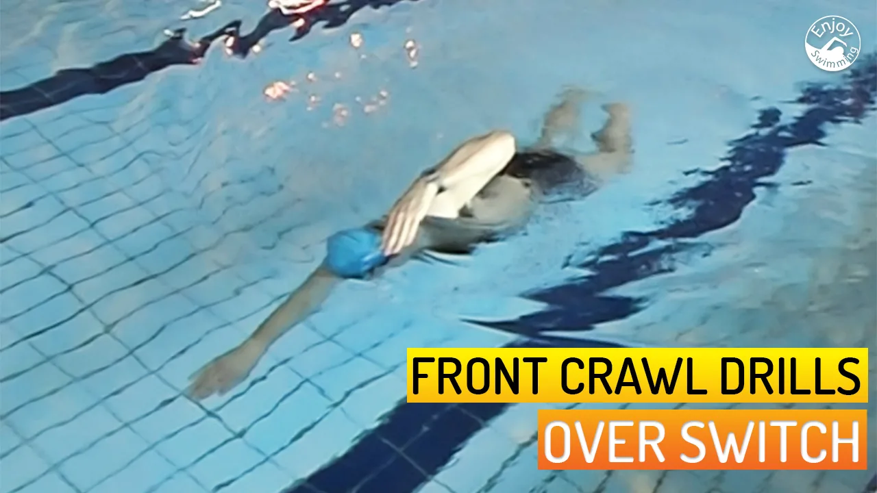 A novice swimmer who practices the over switch drill for the front crawl stroke.