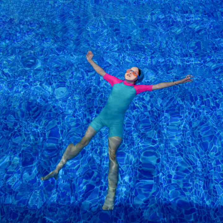 A child floating in the water using the starfish float technique.
