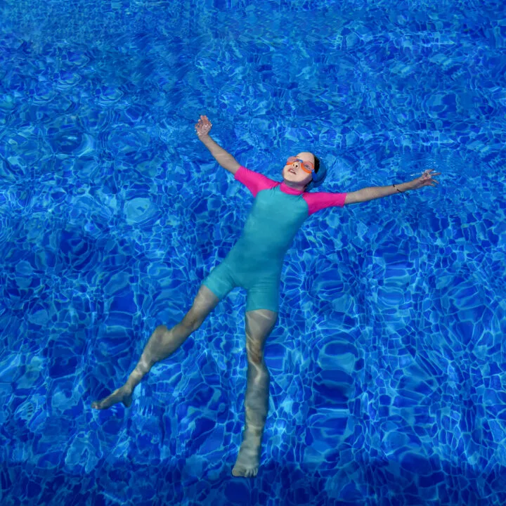 A child floating in the water using the starfish float technique.