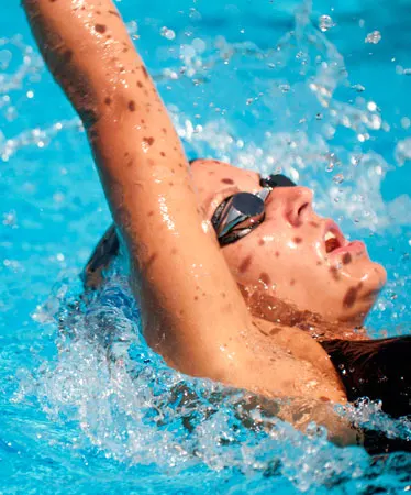 Close-up of the face of a backstroke swimmer while she breathes in.